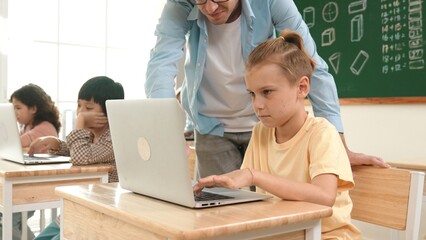 Fototapeta premium Smart caucasian boy using laptop to generated AI by coding engineering prompt. Diverse student learning or studying programing system while attending in STEM technology class. Technology. Pedagogy.