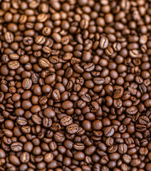 Obraz premium Detailed close-up of a pile of roasted coffee beans, emphasizing their rich brown tones, smooth surface, and natural texture.