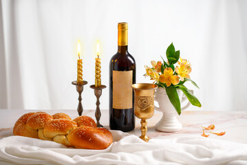 Challah bread, shabbat wine and candles on white bacground. Traditional Jewish Shabbat ritual. Shabbat Shalom.