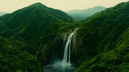 Majestic Waterfall Plunging Through Lush Green Mountains - Aerial Photography
