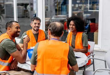 Multiracial engineers having a coffee break, discussing in the factory