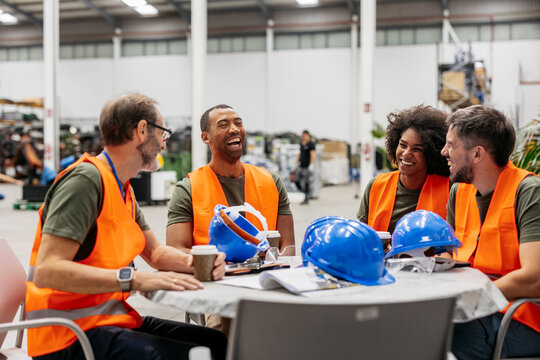 Multiracial engineers team enjoying coffee break in factory