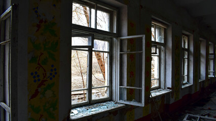 Fototapeta premium open window with old wooden frame. old window. finely broken glass. old house, retro. cracked window frame. cracked old paint, pieces of glass. space for text. large pieces of glass. horror