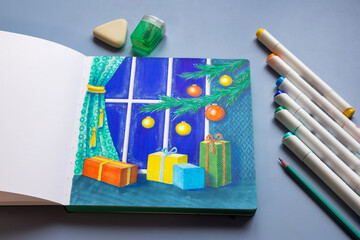 Drawing with markers in a sketchbook on the Christmas theme - a Christmas tree with decorations and gifts
