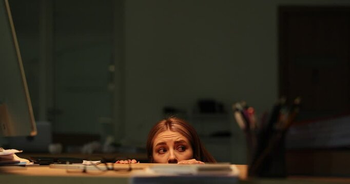 Young businesswoman hides under desk feeling anxious. Female worker experiences panic under pressure of overwhelming workload in office during thunderstorm