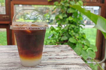 Iced americano coffee mixed with coconut on wooden table