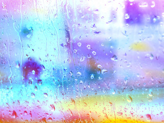 Fototapeta premium Colourful rainy window with raindrops in rainy day. Abstract drops flowing down on a window surface. Textured wallpaper. Wet glass in a stormy weather