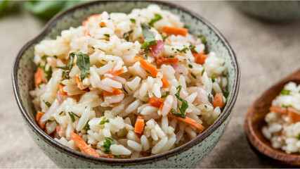Rice-Based Salad: A bowl of rice salad with finely chopped carrots, onions, and herbs, accompanied by a wooden spoon and a hint of basil, resting on a textured surface.