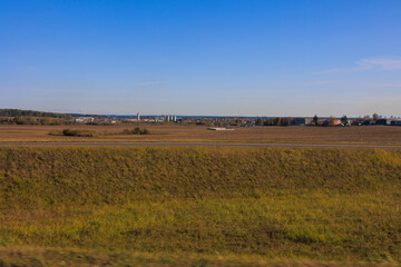 Obraz premium Road shoulder on a sunny autumn day. Views of the landscape from the car window.