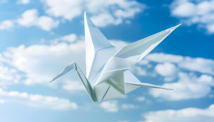 Origami art. White handmade paper crane on sky background, space for text.