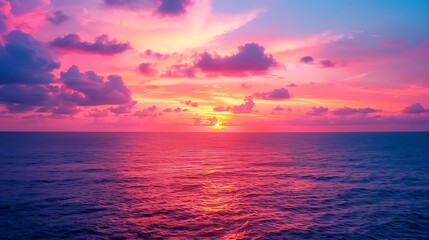 Fototapeta premium A sunset over the ocean with the horizon glowing in shades of orange, pink, and purple.