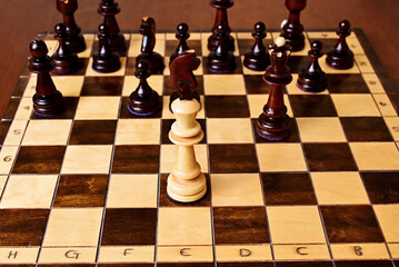 Wooden chessboard with king, knight, bishop and pawns