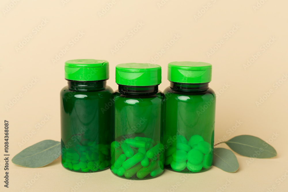 Sticker Bottles with pills and green leaves on color background