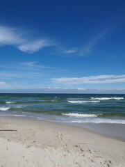 Beach with white sand and blue sky on a summer day by the sea