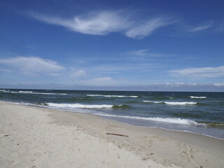 Beach landscape with blue sky and waves on the shore on a summer day