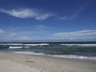 Beach with waves and blue sky on a clear day at the coast