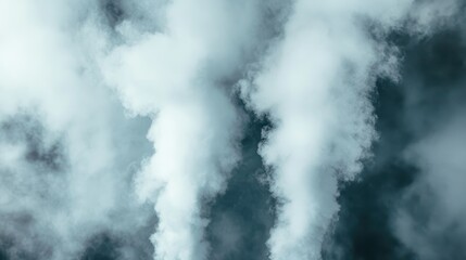 Obraz premium The image shows dense white smoke rising dramatically into the blue sky, conveying a sense of power and energy, accentuated by the stark contrast of colors.