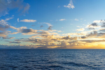 Morning on the Pacific Ocean with golden clouds and a horizon