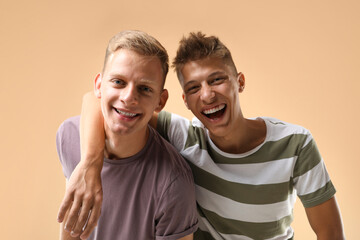 Obraz premium Portrait of happy brothers on beige background