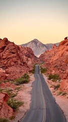 Desert road winding through red rock canyons at sunrise