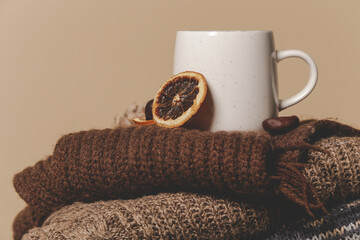 Cozy winter lifestyle concept. Cup of hot drink with warm knitted clothes.	
