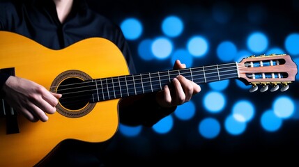 Obraz premium Musician plays acoustic guitar on stage with blue bokeh lights in the background during an evening performance