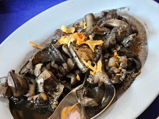 Savoring local delicacy squid ink dish coastal restaurant culinary experience modern setting close-up gastronomic adventure
