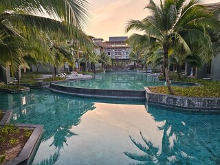 Obraz premium Tranquil evening reflections luxury resort poolside view tropical oasis serene environment relaxation concept