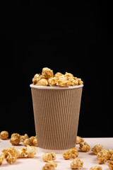 Sweet caramelized popcorn in a bucket. Black background. Place for text