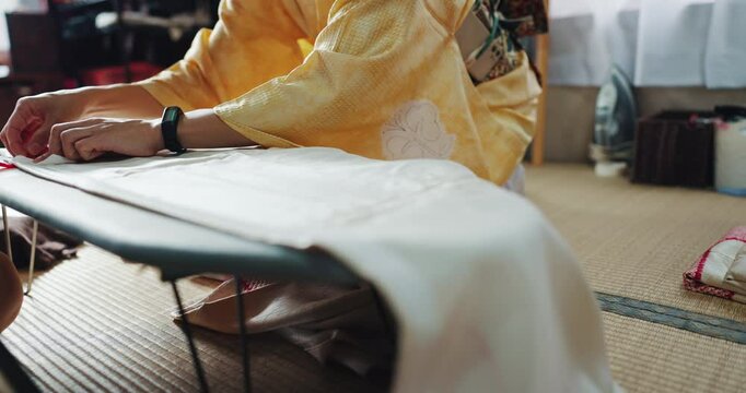 Woman, sewing and hands for tailoring clothes, boutique and design kimono for customer in Japan. Person, small business and style fabric on board, material pattern and production process in shop