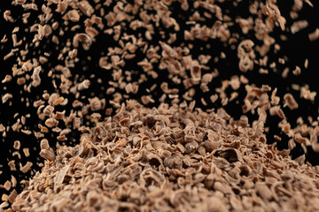 Shredded natural organic chocolate pour on black background