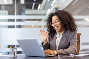A young African-American foreign woman is conducting an anal meeting, sitting in the office behind...