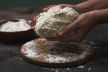 Woman kneading dough at grey table, closeup