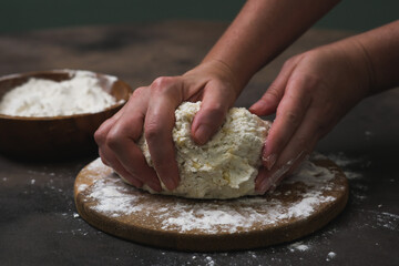 Woman kneading dough at grey table, closeup