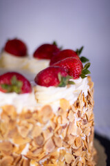 A strawberry cake with white frosting and a very shallow depth of field.
