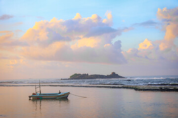 Seascape. A boat on the water against the background of the sunrise.