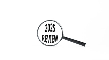 Planning 2025 review new year symbol. Concept words 2025 Review on beautiful white paper in magnifying glass. Beautiful white paper background. Business 2025 review new year concept. Copy space.