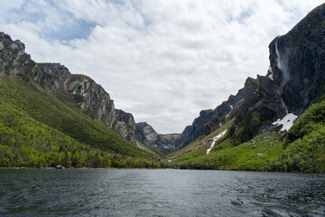 The eastern end of Western Brook Pond, where the fjord meets, reveals serene waters and towering cliffs, showcasing the dramatic and breathtaking beauty of Gros Morne National Park.