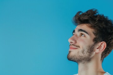 Obraz premium Young man with positive smile isolated on blue background.
