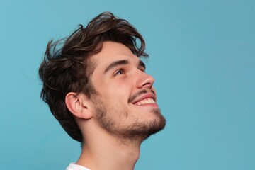 Obraz premium Young man with positive smile isolated on blue background.