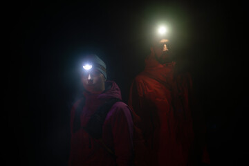 Fototapeta premium trail runners couple portrait while preparing for an early morning run in the night time with a headlamp