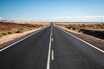 Fototapeta premium Straight black asphalt road with white dividing lines on a sunny day, highway markings, highway signs, highway, roads, concrete