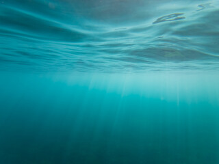 Underwater photography, bright rays of sun penetrate the water, south France Cote d'Azur.