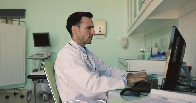Mature GP sit at desk read badly news on computer, feels stressed, concerned due to critical test results, error in medical report or problems with PC usage, negative patient feedback or complaints