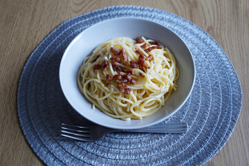 Spaghetti carbonara served for lunch in a plate on the dining table