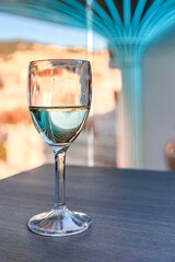 Glass of white wine on table in sunlight. Atmosphere of delightful event.
