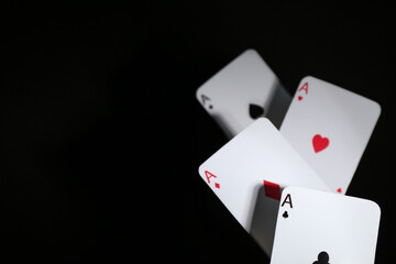 Poker game. Playing cards on black background, closeup. Space for text