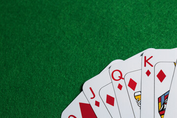 Poker game. Playing cards on green table, top view. Space for text