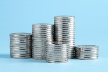 Salary concept. Stacked coins on light blue background
