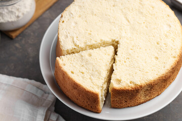 Tasty cut sponge cake on grey table, closeup